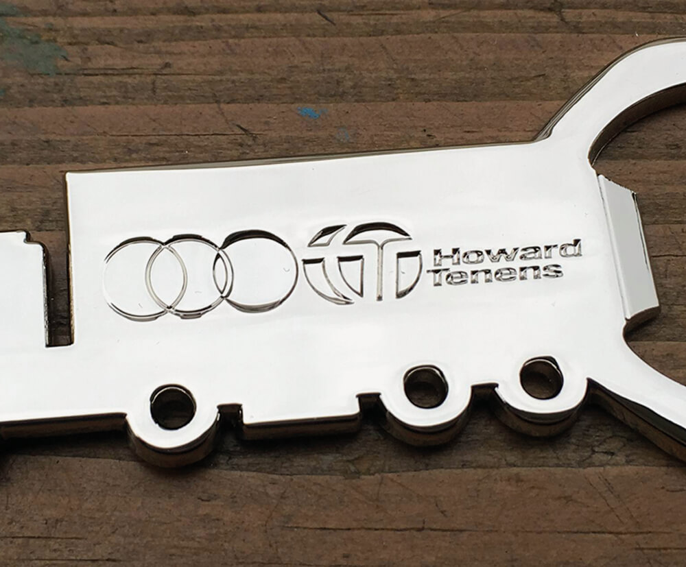 Custom-shaped metal keyring with embossed logo design.