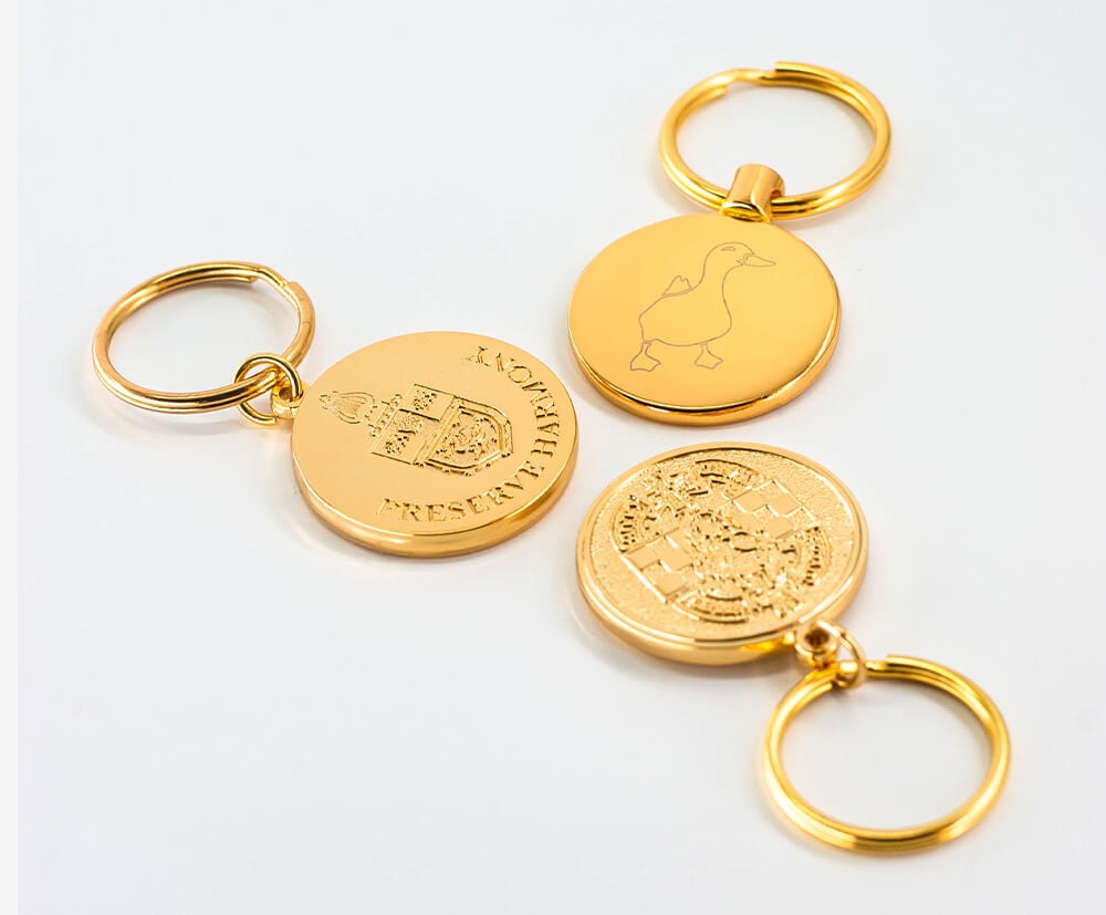 Gold plating on coin-shaped metal promotional keyrings.