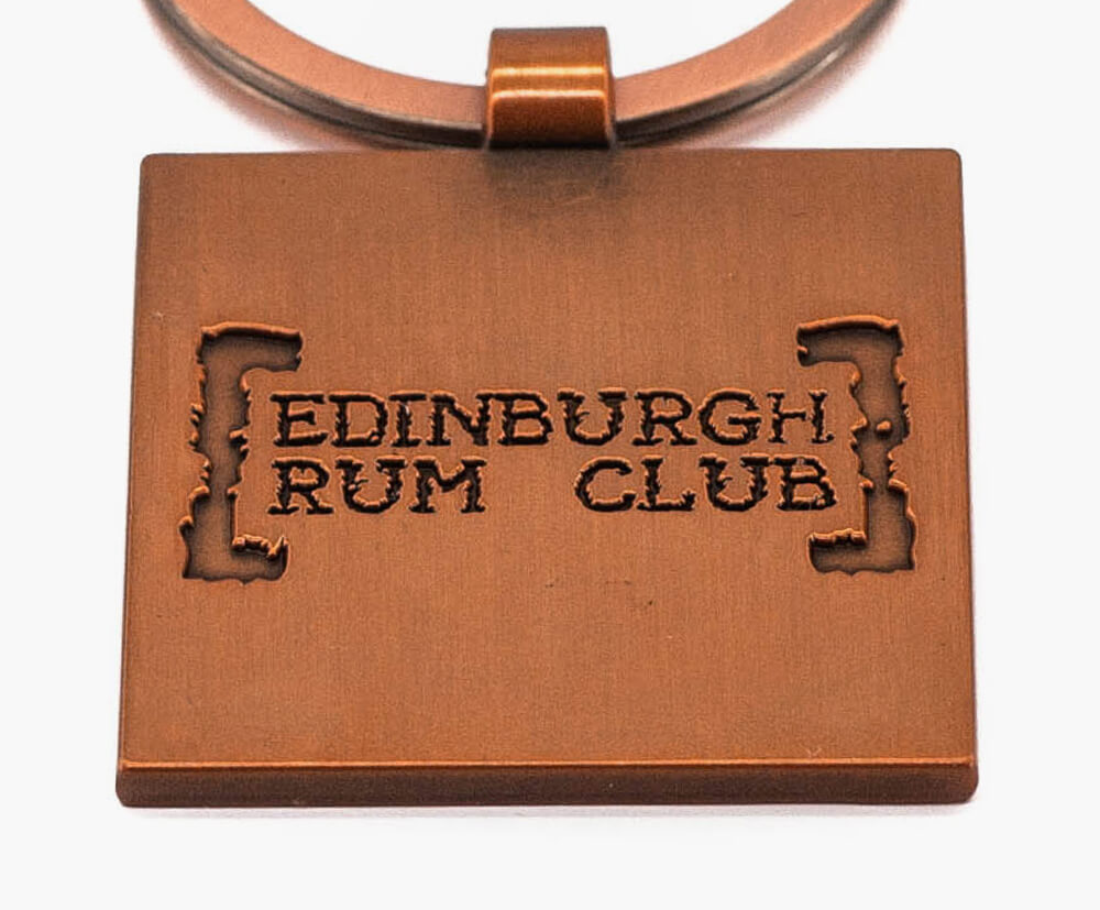 Antique copper-plated metal promotional keyring.