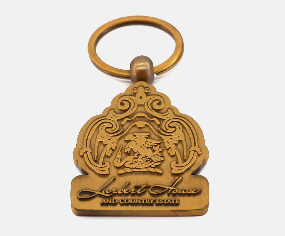 Custom shaped metal promotional keyring with a detailed embossed design.
