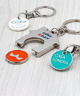 A group of 3 trolley coin keyrings branded with company logos